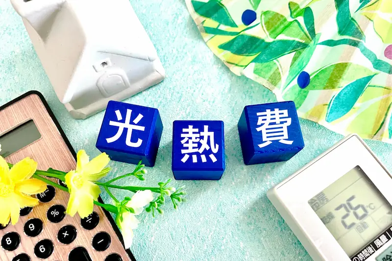 電卓や温度計とともに並ぶ「光熱費」の文字ブロック|ウイングホームのエネルギー効率を考えた住まい