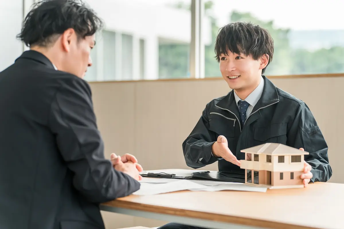 住宅モデルを使って補助金制度を説明する建築担当者