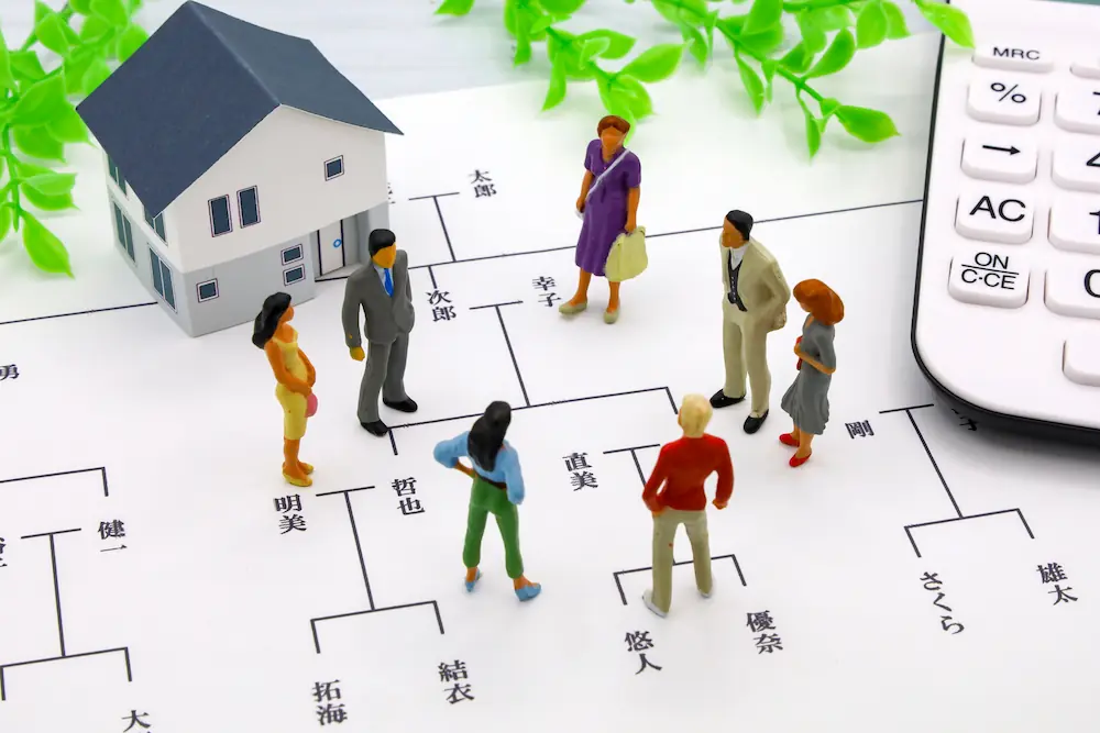 家族で相続について話し合うイメージ（家・土地・家系図）